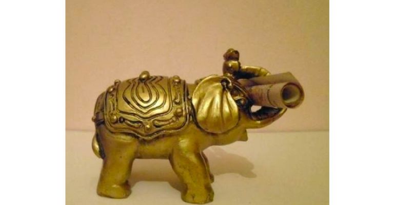 estatuilla de elefante dorado con un billete